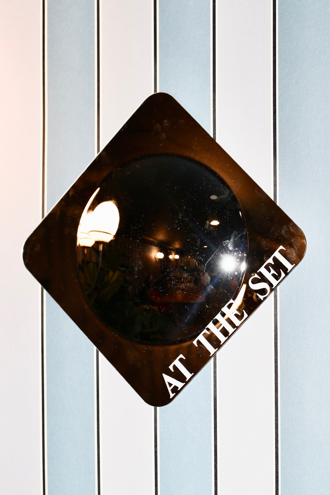 AT THE SET mirror sign on a striped wall